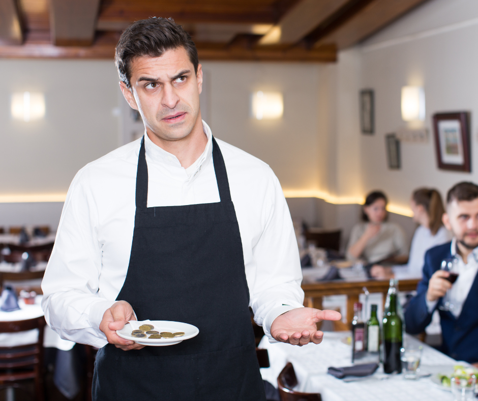 A waiter looking irritated that he was tipped a very meager amount of change.